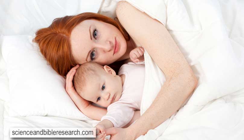 Mother's love - cute baby 3 months boy with mother in bed (Photo by photomak)